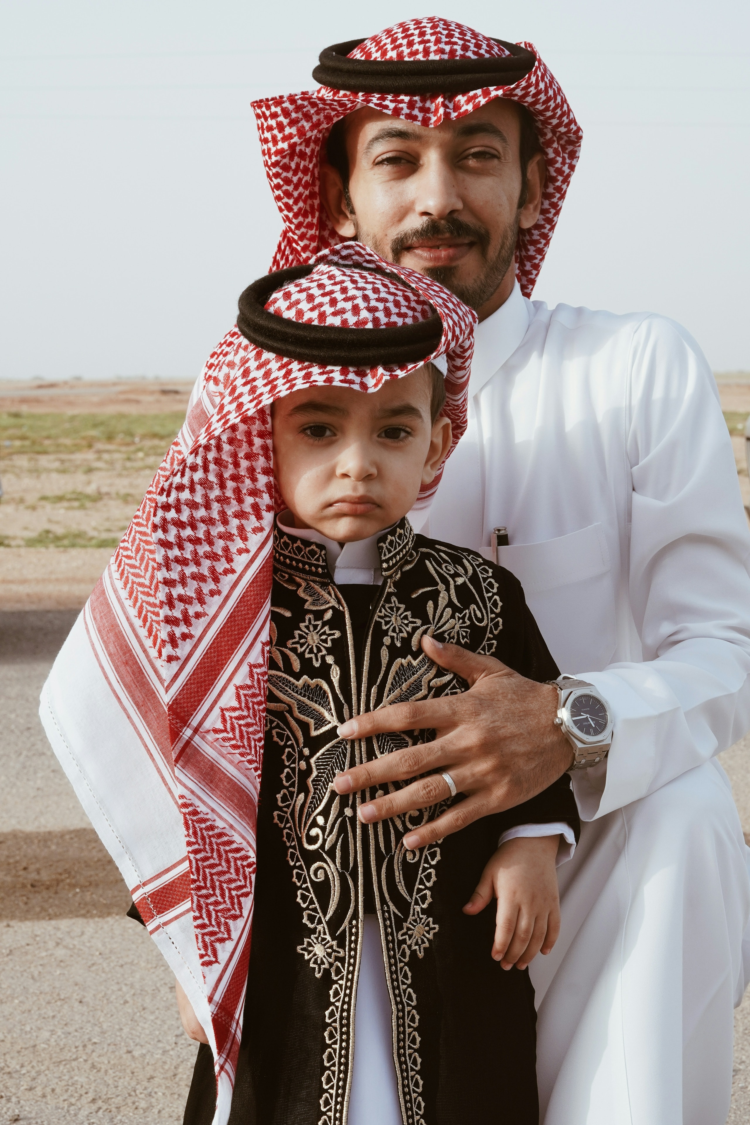 A father and his young son in traditional Gulf dress